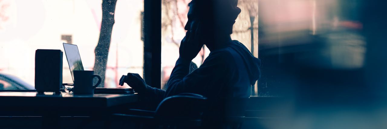 Are Online Chronic Illness Support Groups Helpful or Unhelpful? photo of man sitting in cafe near window with laptop