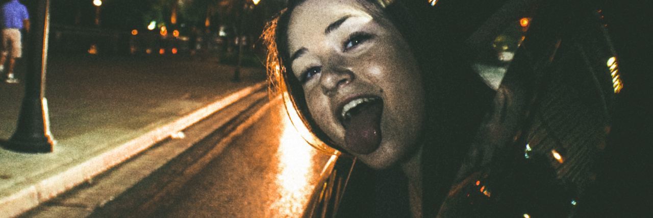 photo of young woman hanging out of car window on vegas strip sticking out tongue