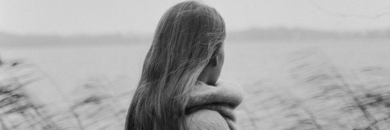 What Doctors Should Tell You About Life With Chronic Illness black and white photo of woman standing against field facing away from camera