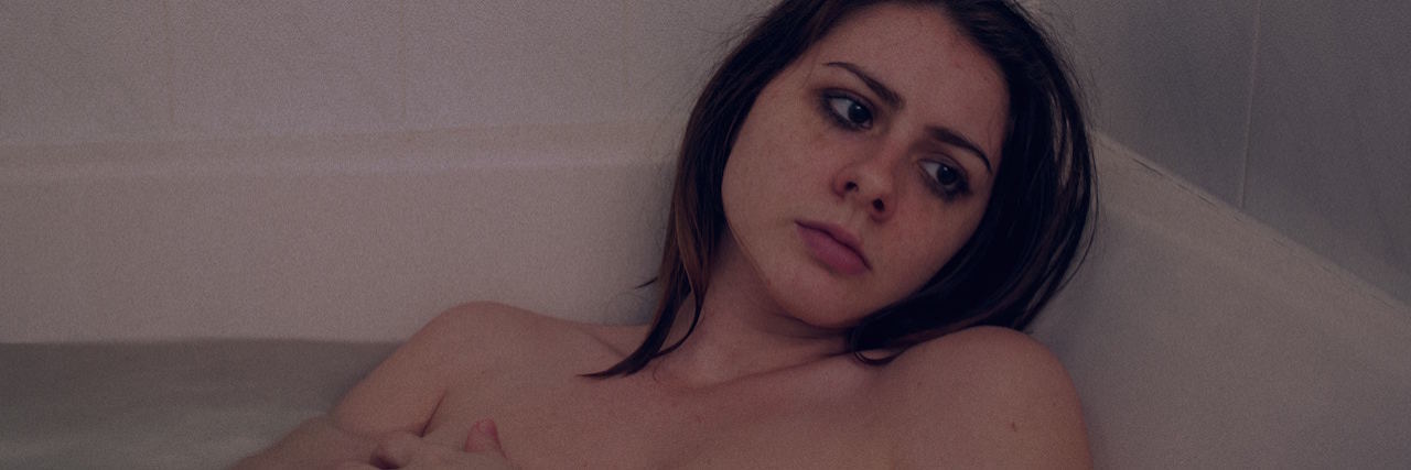 What People With Depression Mean When They Say 'I'm Tired' A woman in a bathtub