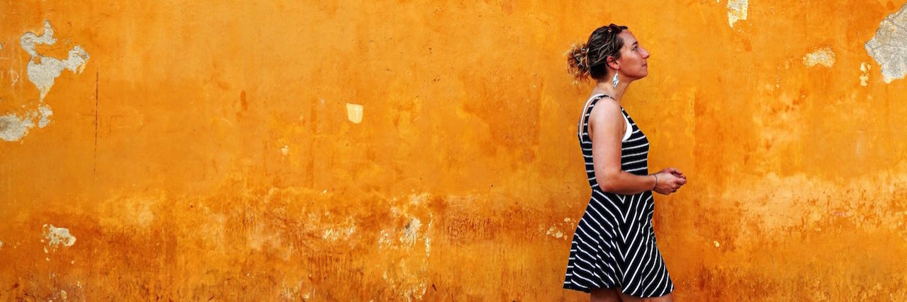 It's OK to Be an Ordinary Person With a Disability A woman walking in front of a wall