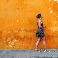A woman walking in front of a wall