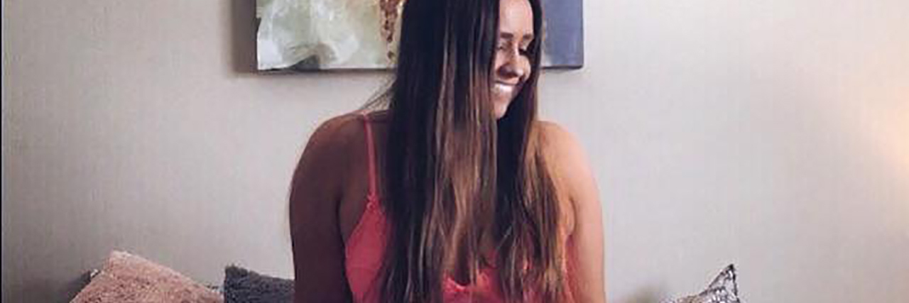 Responding to the Trolls Who Commented With Bipolar Stigma photo of contributor Megan Rowe sitting on bed smiling