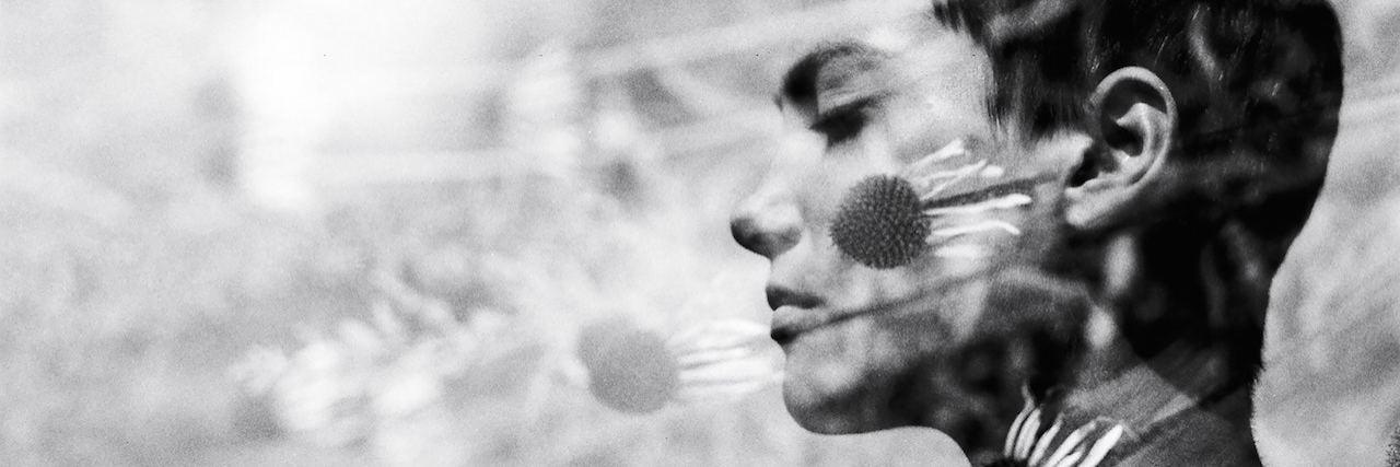 Hidden Depression Symptoms on People Who Seem 'Normal' A woman with short hair, overlaid with flowers