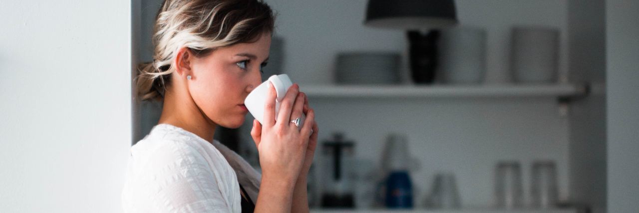 How Common and How Serious Is Loneliness? photo of young woman sitting on kitchen worktop drinking coffee