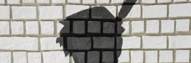 Painted silhouette Peter Pan on white brick wall