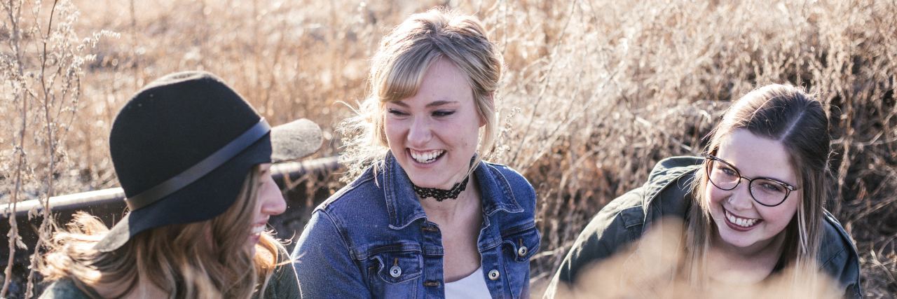 Standing Up for Friends Who Have Physical Disabilities three friends smiling and talking with each other in a field