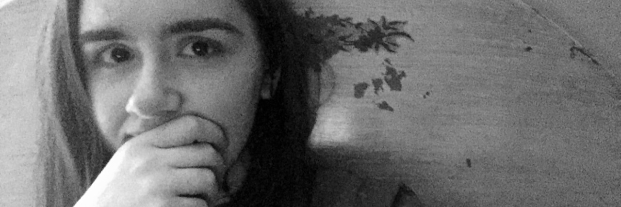 I'm Done Apologizing for My Learning Disability Black and white photo of Erin looking serious with her hand over her mouth and chin.