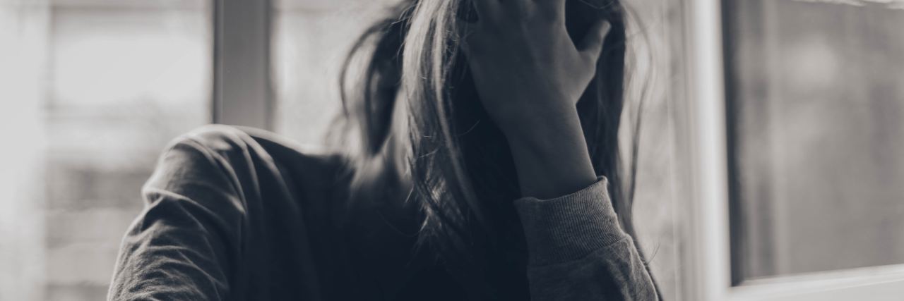 When You Feel Like Depression Is Your Whole Identity black and white photo of woman with hand in hair covering face