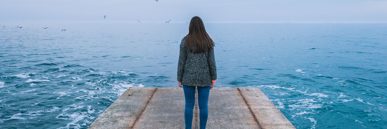 How Depression Recovery Is Painful but Peaceful photo of woman standing on pier looking into distance over rough sea or lake at misty horizon