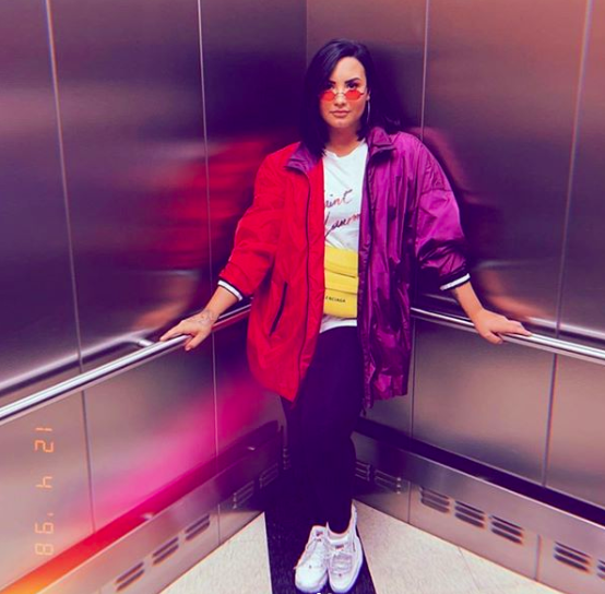 Demi Lovato posing in the corner of an elevator