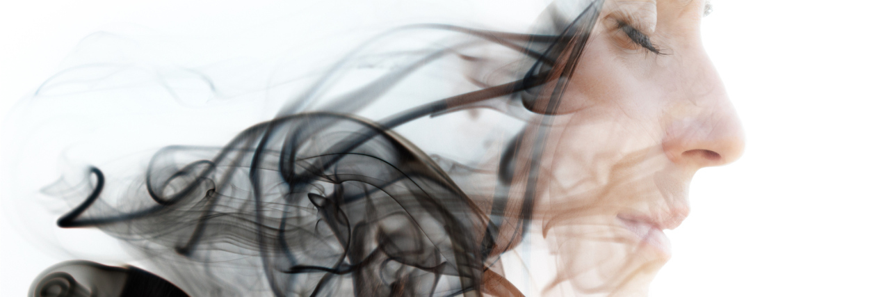 Derealization Makes People Check Out Of Their Bodies Double exposure photograph of a young woman combined with an image of the smoke