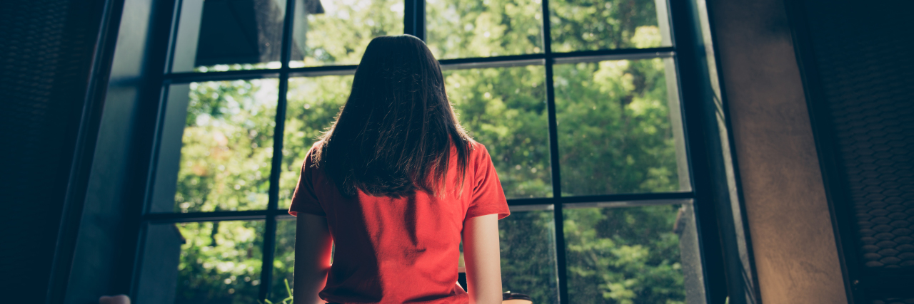 Chronic Migraines and Mental Health Woman looking out window.