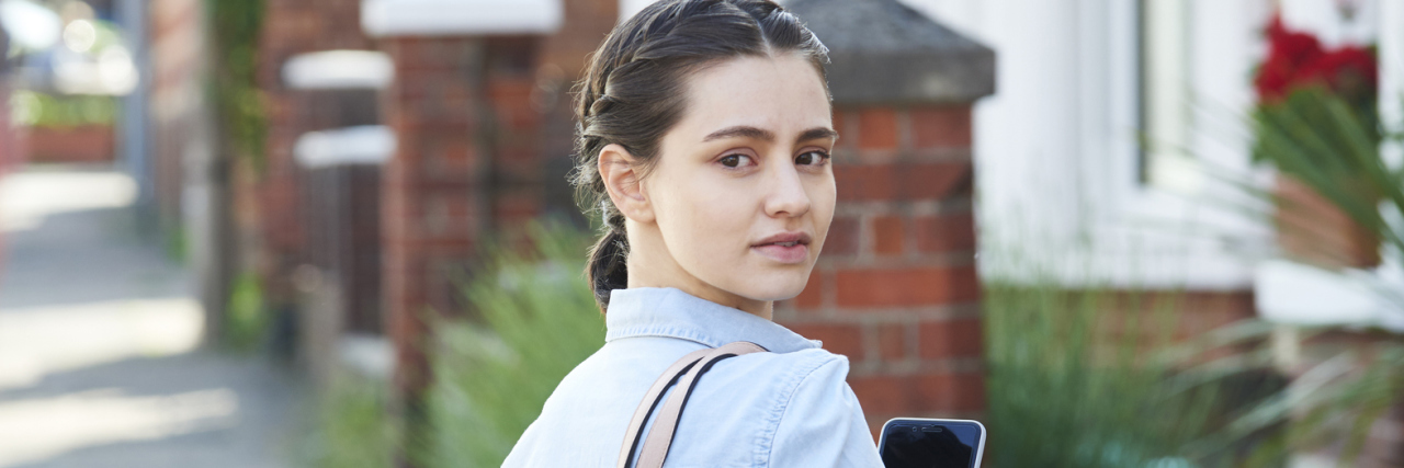 Hypervigilance and Paranoia woman looking over her shoulder at man walking behind her