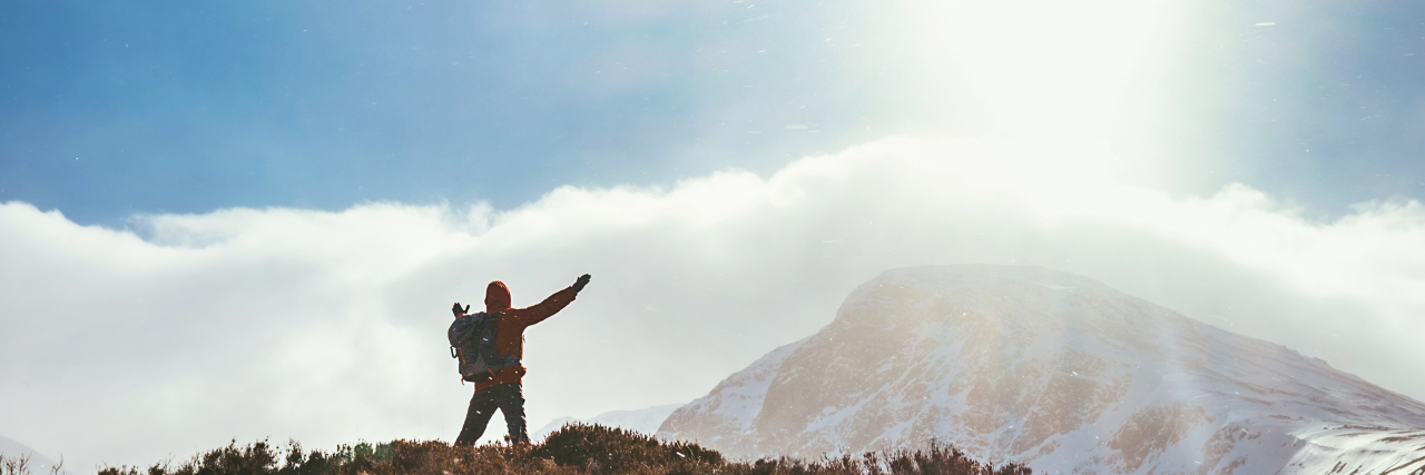 Overcoming Challenges in Life With Epilepsy Mountain hiker greeting the sun in Highland.
