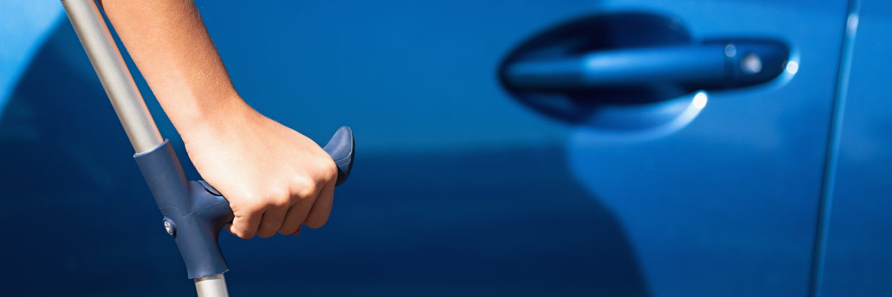 Receiving Unwanted Help Because of a Disability Woman with crutches opening door of car.