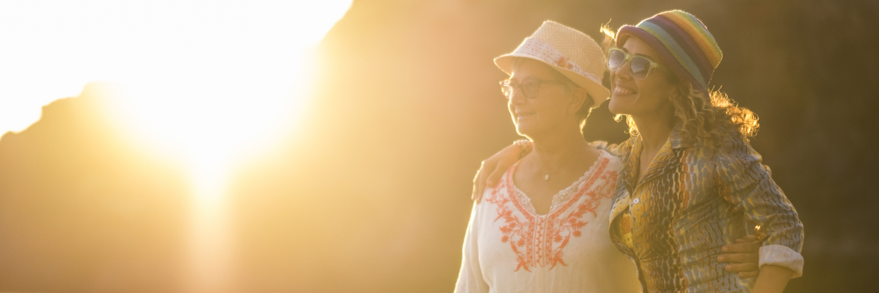 3 Simple Tips to Prevent Caregiver Stress Mother and daughter caucasian people friends at the beach hugging and having fun smiling with golden sun in backlight and ocean in background - family and mixed diversity generations concept