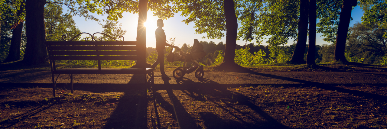 How I Overcame Postpartum Depression and Anxiety silhouette of a mom walking in park with her baby