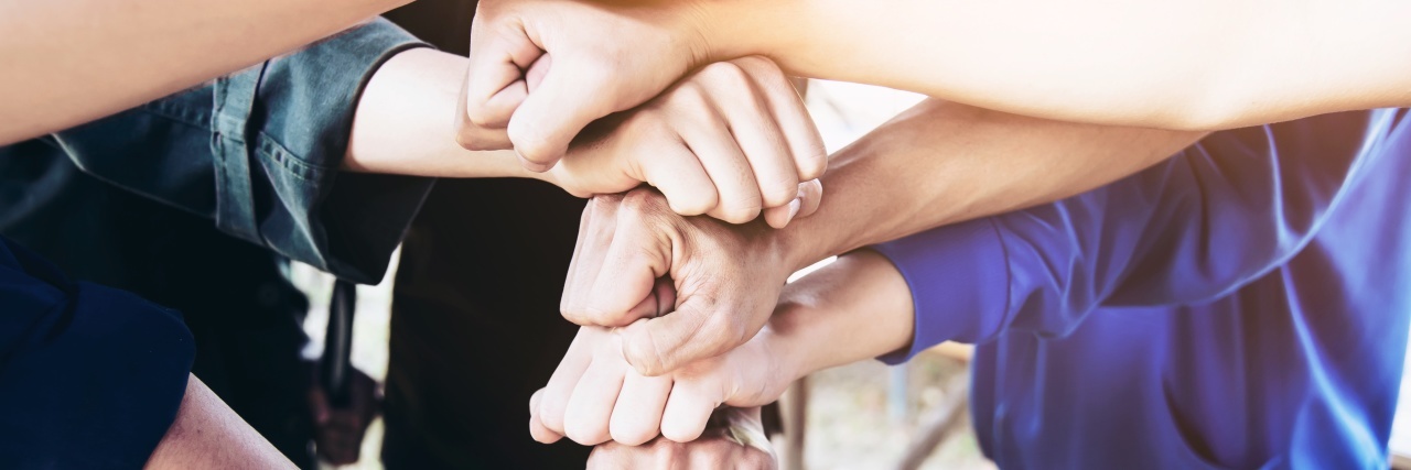 How You Can Support a Person With Depression a group of hands symbolizing teamwork
