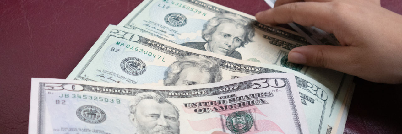 The Odd Symptom of BPD I Didn’t Realize I Had Man holding dollar banknote.young businessman holding money.Business and finances making and saving money concept.