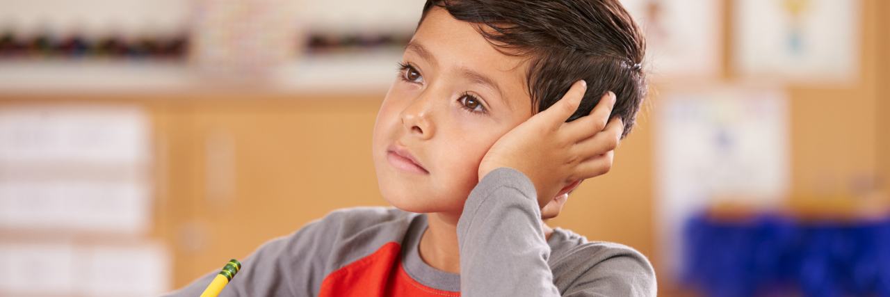 Moving Beyond Fear of Your Child Receiving an ADHD Diagnosis Boy daydreaming in an elementary school class.