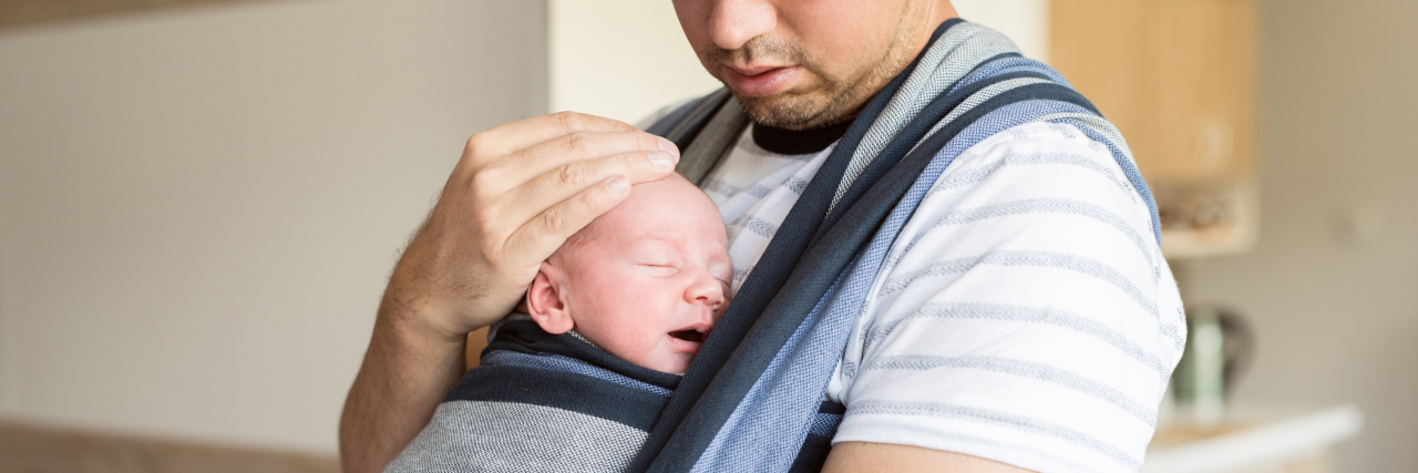 Being a Father With Cerebral Palsy Father holding baby in sling.
