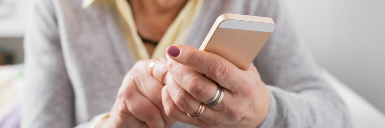 Study Finds Falling for Phone Scams Could Be Sign of Dementia Risk Senior woman holding smartphone in hands and exploring new technology