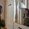 woman looking into mirror and smiling
