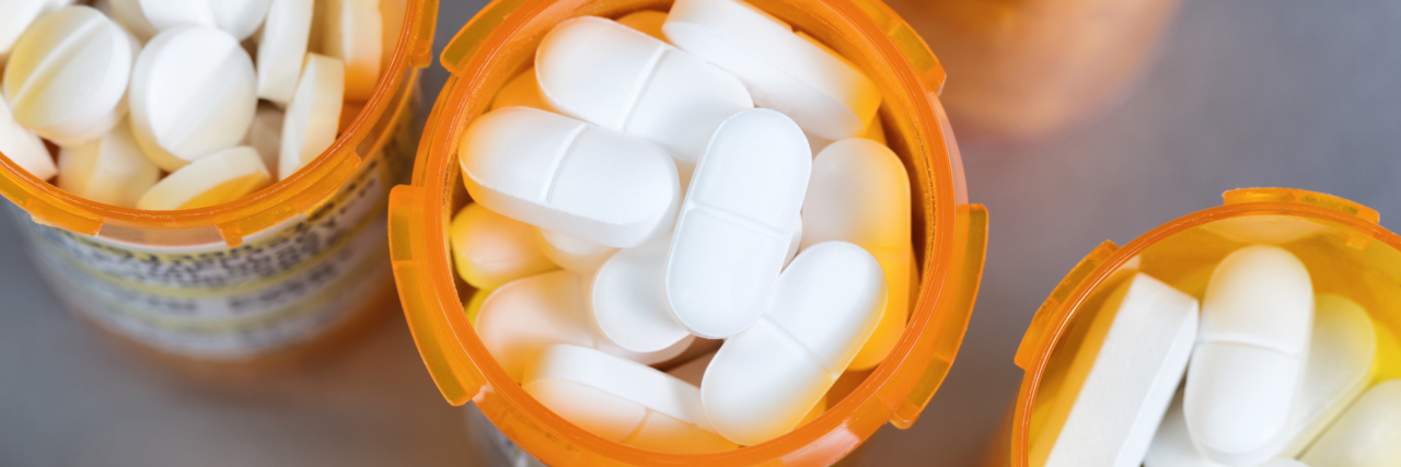 top view of prescription bottles full of white pills