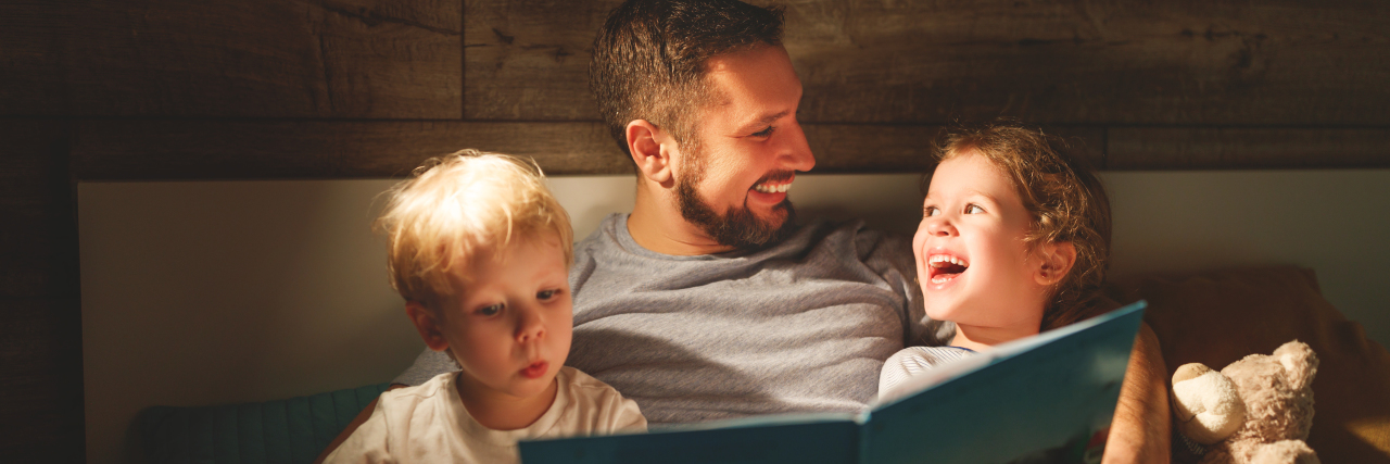 Celebrating What Matters During Autism Awareness Month Father reads to his sons.