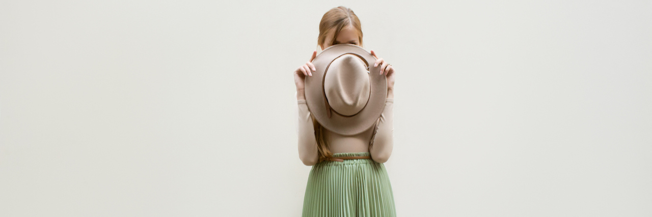 Dressing Modestly After a Sexual Assault Young red hair girl in hat, dressed in beige blouse and turqoise pleats skirt, on light street background