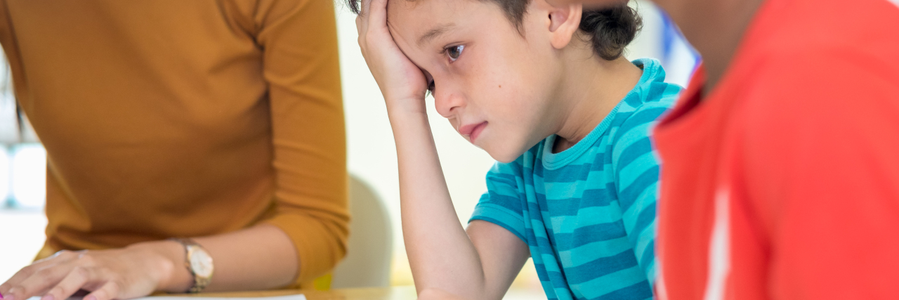 How Autistic Children Are Shamed in School Sad boy in classroom.