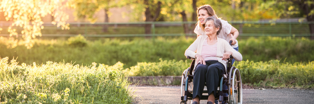Why Honesty Isn't Always the Best Policy for People With Dementia lderly grandmother in wheelchair with an adult granddaughter outside in spring nature.