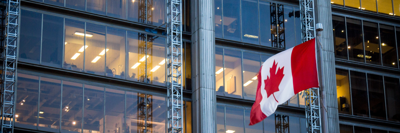 Canadian flag in front of a business building in Toronto, Ontario, Canada.