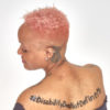 Keisha, African-American woman with pink hair and tattoos.