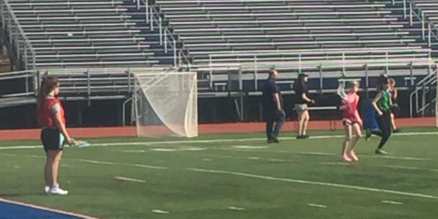 Young girls on a field playing lacrosse