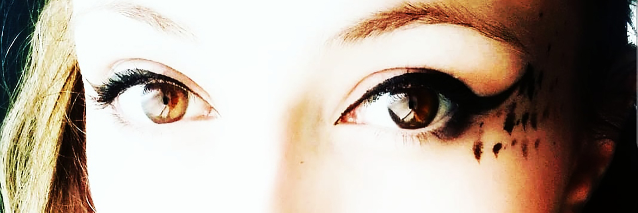 Borderline Personality Disorder, Identity and My Reflection photo of young woman wearing elaborate eye make up looking into camera with sad expression