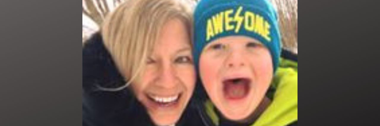 Mother and son with Down syndrome smiling at camera