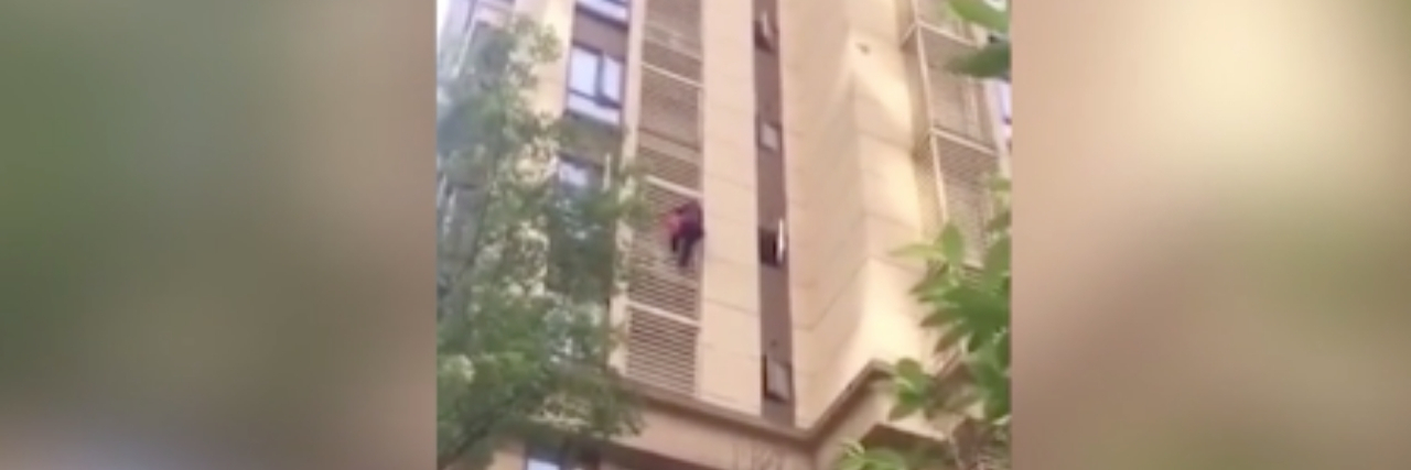 Video Shows Woman With Alzheimer's Climbing Out Window woman climbing down outside of tall building