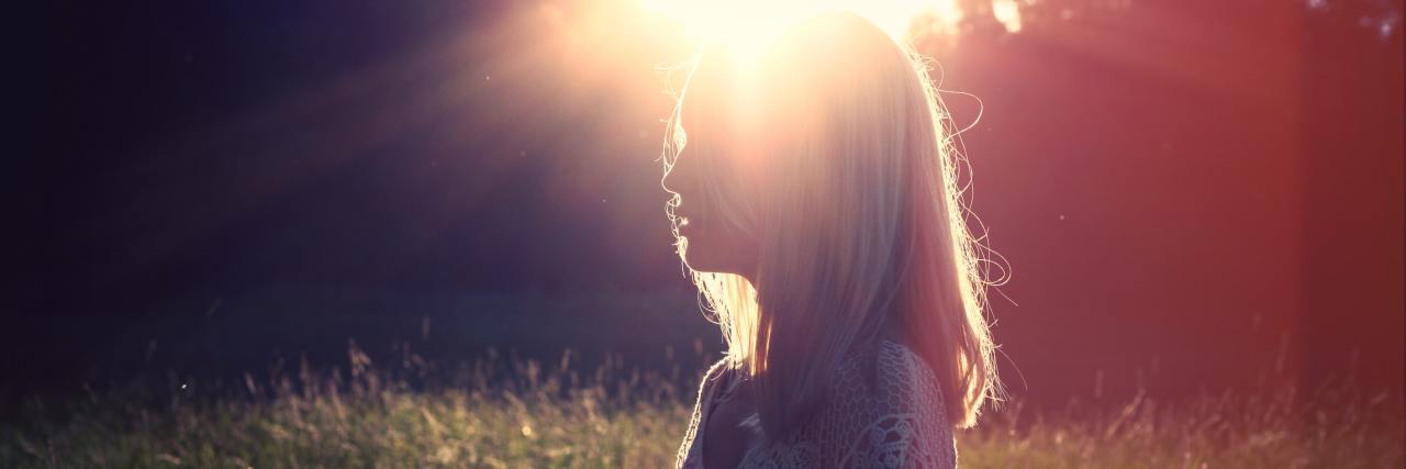 My VIP Approach to Beating Rectal Cancer woman outside in field with sun flare behind her