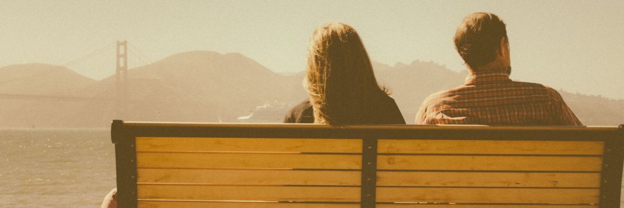 How to Tell Your Partner You Have Borderline Personality Disorder photo of couple on bench in san francisco looking out over bay with bridge in distance. A dog is sitting between them.
