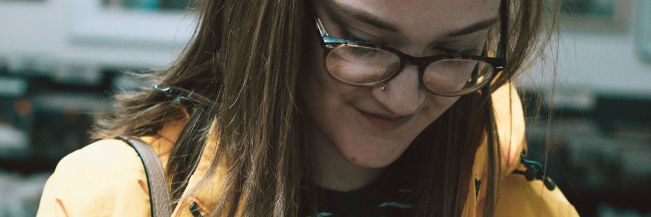 How 'Dungeons & Dragons' Helps With My Depression photo of geek girl wearing glasses and yellow coat looking down at LP vinyl