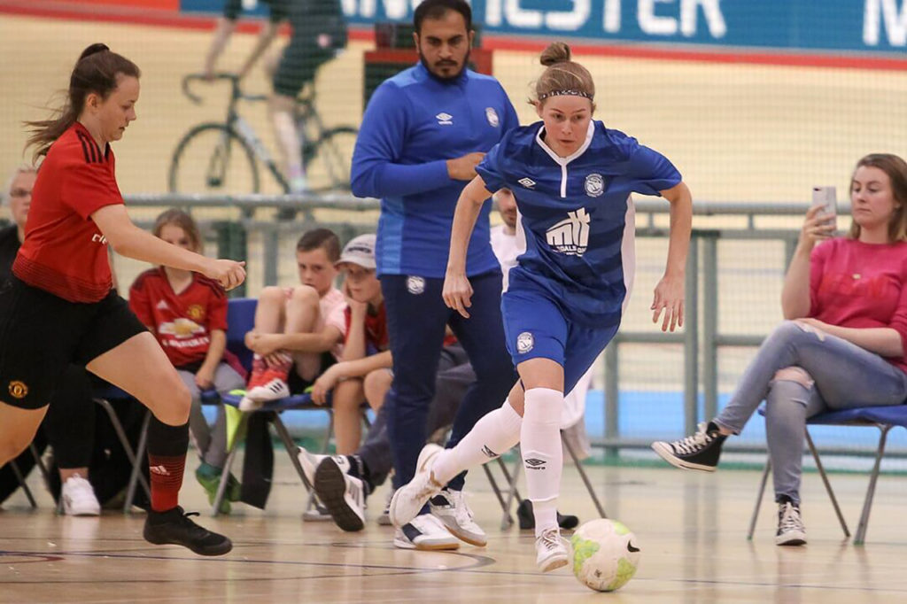 photo of contributor leanne skarratt playing soccer in blue kit while being chased by another female player