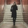 photo of woman alone about to climb stairs in subway