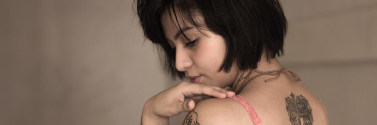 The Frustrating Symptom of Depression We Need to Talk About woman looking over shoulder