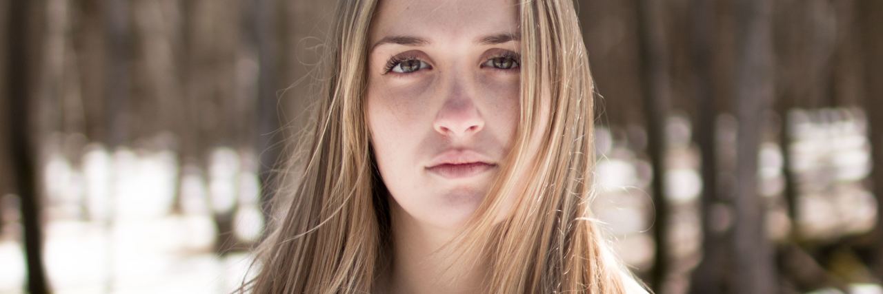 Purging Disorder: The Eating Disorder Like Bulimia, Without Binging photo of young blonde woman standing in forest with trees behind her