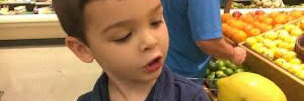 Making a Supermarket Outing Successful for Kids on the Autism Spectrum Little boy with autism holding a lemon at the supermarket.