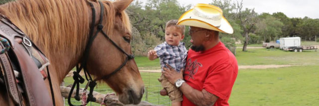 Burn survivor introducing his child to a horse.