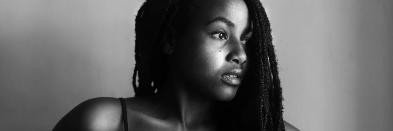 black and white photo of woman looking spaced staring out of window