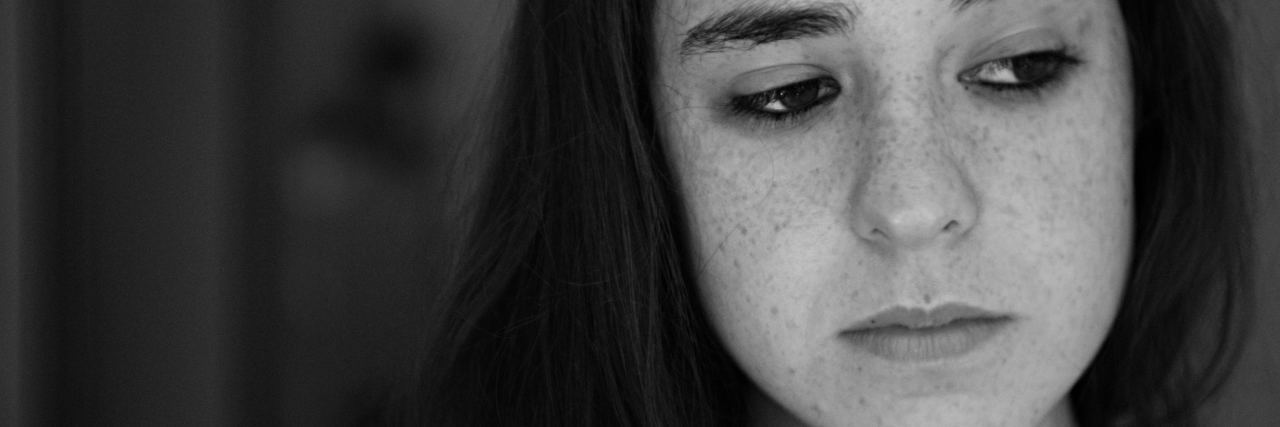 I'm Struggling to Think of My Sexual Experience as Rape black and white photo of young woman with dark hair looking away mournfully or lost in thought